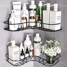 two tiered bathroom shelf with soaps, lotions and flowers in vase on tiled wall