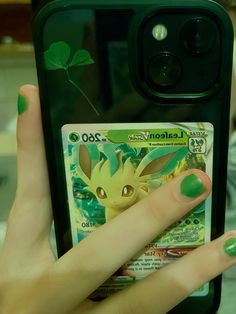 someone holding up their cell phone to take a photo with the pokemon card on it