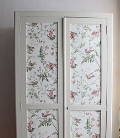 a white armoire with birds and flowers on it