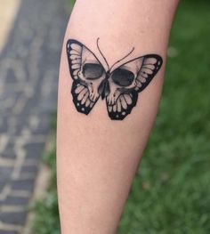 a black and white butterfly tattoo on the leg