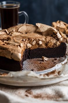 a piece of chocolate cake sitting on top of a plate next to a cup of coffee