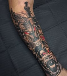 a man's leg with a tattoo on it that has a wolf head and red eyes