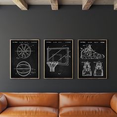 three framed drawings hang on the wall above a leather couch in a living room with a basketball hoop