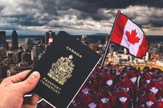 a canadian passport being held up in front of a cityscape with the canadian flag