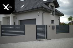 a grey house with a black fence and gate