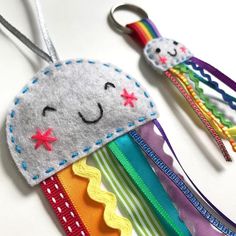 a close up of two small key chains on a table with other items in the background