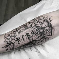 a man's arm with an arrow and flowers on it