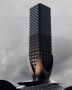 a tall building that is sitting in the middle of a cloudy sky with an intricate design on it's side