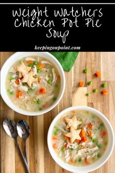 two bowls of chicken pot pie soup on a wooden table with spoons and green napkin