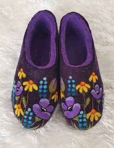 a pair of purple slippers with flowers painted on them