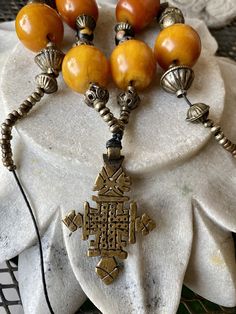 Bold Copal Amber Resien Ethiopian Cross Vintage Necklace necklace measures aprox 28 inches around Spiritual Long Necklace For Festivals, Gold Jewelry With Hand-knotted Round Beads, Spiritual Yellow Hand-strung Necklaces, Bohemian Cross-shaped Beaded Necklaces, Spiritual Yellow Hand-strung Necklace, Bohemian Beaded Cross Necklace, Orange Necklace For Festivals, Traditional Single Strand Necklaces For Festivals, Traditional Single Strand Festival Jewelry