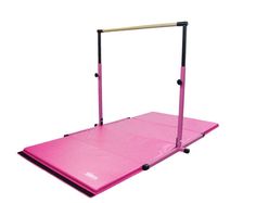 a pink gymnastics mat with bars on top and one leg raised up to the side