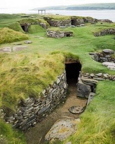 an old stone building with grass growing out of it