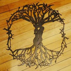 a metal tree with roots on a wooden floor