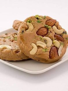 two cookies with nuts and pistachios are on a plate