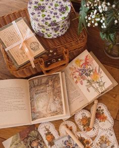 an open book sitting on top of a wooden table next to flowers and other items