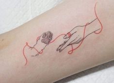 a woman's arm with an outline of a hand holding a dog's paw