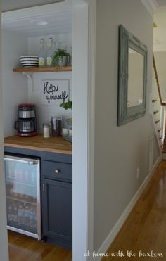 an open refrigerator in a kitchen next to a wooden floor and stairs leading up to the second floor