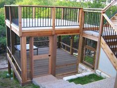 an outdoor caged in area with stairs leading up to the top floor and second story