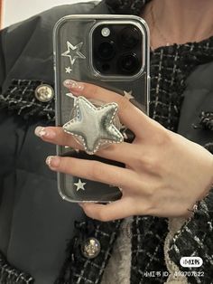 a woman is holding up her phone case with a silver star ring on it's finger