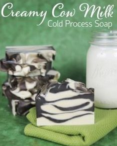 a soap bar sitting on top of a green towel next to a jar of milk