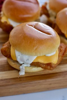 chicken sandwich with cheese and mayonnaise on wooden cutting board