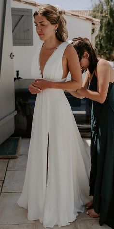 a woman in a white dress standing next to another woman