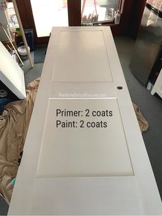 a white door with the words primer 2 coats paint 2 coats on it in front of a refrigerator