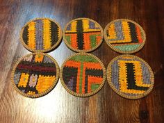 four woven coasters with different designs on them