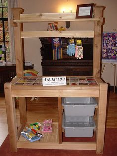 a wooden table with two bins on it and a sign that says 1st grade