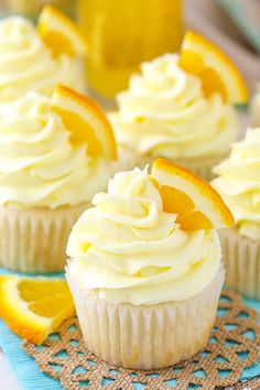 cupcakes with frosting and orange slices on a doily