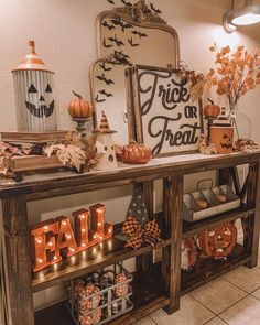 a table with pumpkins and decorations on it in front of a sign that says trick or treat