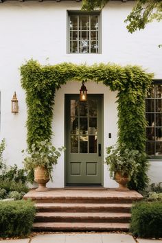 a white house with ivy growing over the front door and steps leading up to it