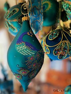 several ornaments are hanging from the ceiling in blue and green colors, including peacocks