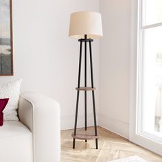 a living room with a white couch and floor lamp