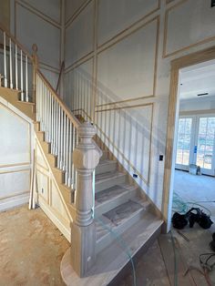 an unfinished staircase in a house with no carpet on the ground and walls painted white