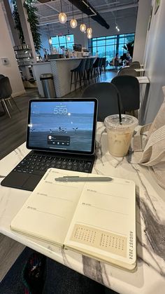 an open laptop computer sitting on top of a table next to a cup of coffee