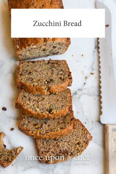 sliced zucchini bread on a cutting board next to a knife