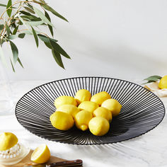 a black bowl filled with lemons on top of a table