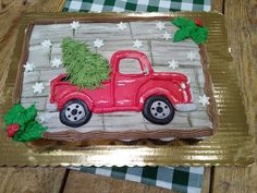 a decorated cake with a red truck carrying a christmas tree