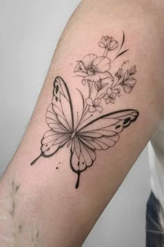 a black and white butterfly tattoo on the arm