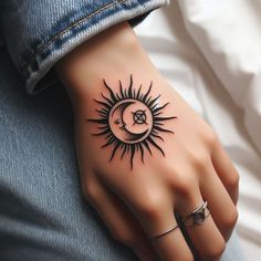 a woman's hand with a sun and moon tattoo on it