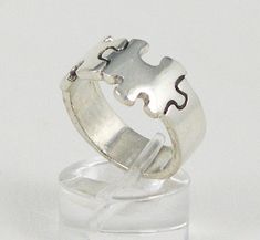 a silver ring with puzzle pieces on it