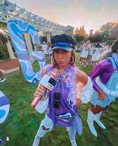 a woman dressed in costume holding a microphone and talking to someone on the sidelines