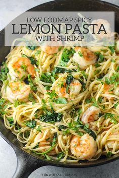 lemon pasta with shrimp and spinach in a skillet on top of a table