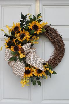 a wreath with sunflowers is hanging on the front door