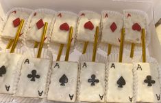 a box filled with white frosted cakes covered in playing cards