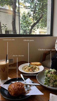 a person sitting at a table in front of a window with food on the plate