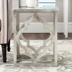 a white table sitting on top of a rug next to a couch