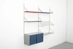 a white wall with three shelves on it